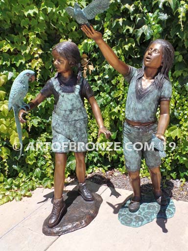 Bird Lovers bronze statue of two girls playing with their pet birds