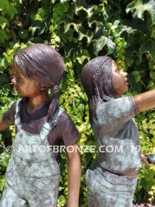 Bird Lovers closeup B bronze statue of two girls playing with their pet birds