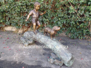 Adventurous Pals Bronze monumental sculpture for garden or yard of boy and dog crossing bronze log