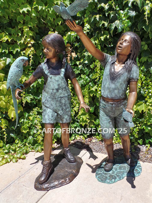 Bird Lovers bronze statue of two girls playing with their pet birds