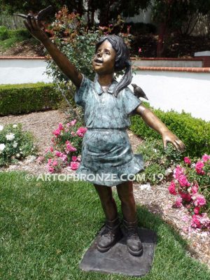 Birds of Joy front view bronze statue of standing girl w/ dress and birds in hands