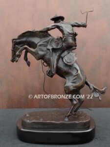 The Bronco Buster bronze sculpture after Frederic Remington featuring cowboy on horse