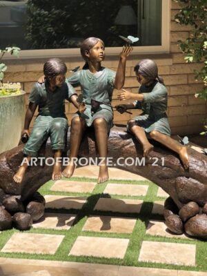 Butterfly Enchantment bronze sculpture of three kids sitting on log with butterfly net