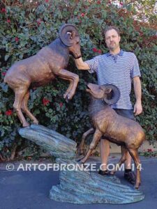 Clash of the Titans special edition, monumental outdoor rams clashing on bronze rock ledge