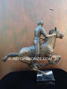 Downfield bronze sculpture of polo player riding his leaping polo pony attached to a marble base