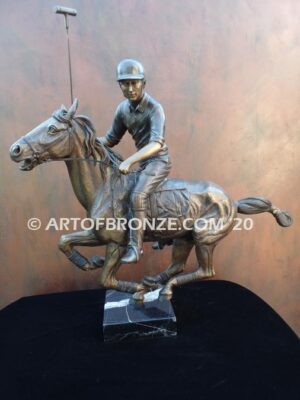 Downfield bronze sculpture of polo player riding his leaping polo pony attached to a marble base