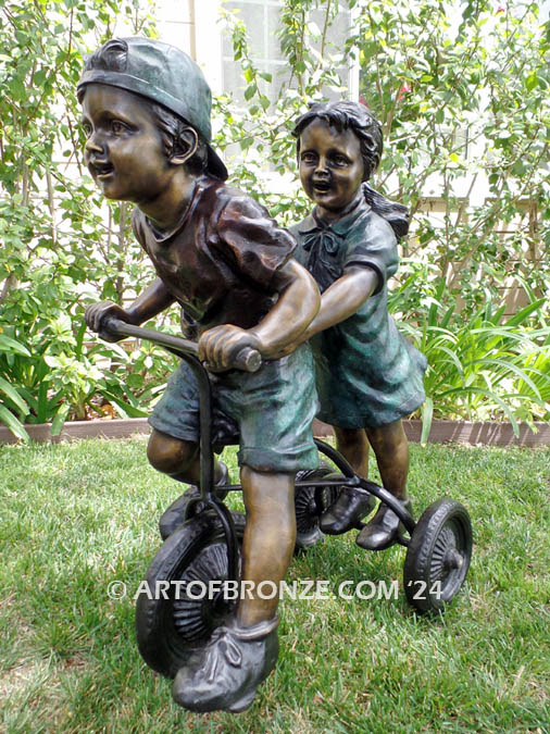 Endless Summer bronze statue of boy and girl children riding tricycle