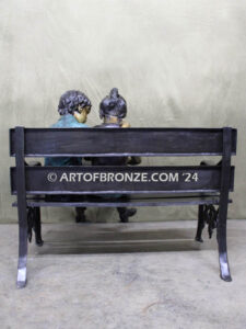 Friendship outdoor bronze garden sculpture of two children reading a book on bench