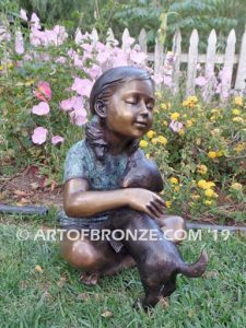 Give me Attention bronze sculpture of girl sitting with crossed legs dog on her lap