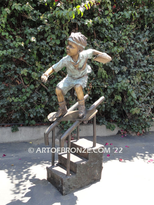 Goin’ Big bronze sculpture of young skateboarder doing a rail slide