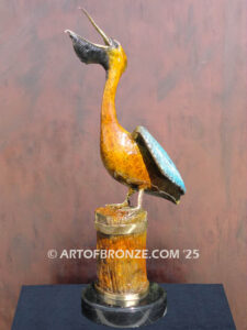 Bronze statue of pelican on piling swallowing a fish