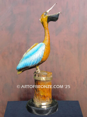 Bronze statue of pelican on piling swallowing a fish