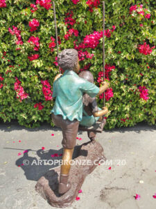 Higher & Higher outdoor bronze sculpture of boy pushing girl on swing