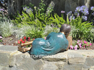 Honor Roll bronze sculpture of girl lying down looking at book