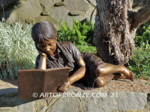 Honor Roll bronze sculpture of girl lying down looking at book