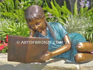 Honor Roll bronze sculpture of girl lying down looking at book