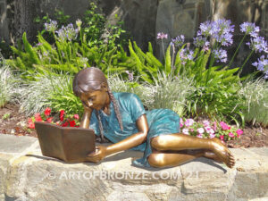 Honor Roll bronze sculpture of girl lying down looking at book