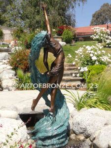 Inspirare beautiful woman leaping upward with spiraling wave design around her bronze statue