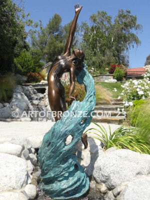 Inspirare beautiful woman leaping upward with spiraling wave design around her bronze statue