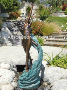 Inspirare beautiful woman leaping upward with spiraling wave design around her bronze statue