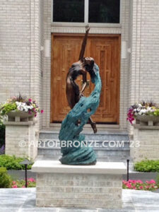 Inspirare beautiful woman leaping upward with spiraling wave design around her bronze statue