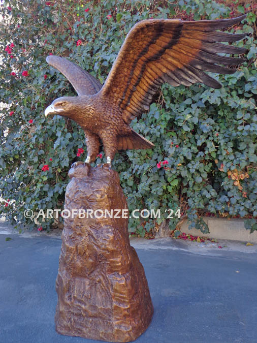 Land of the Free bronze statue of eagle landing on rock monument