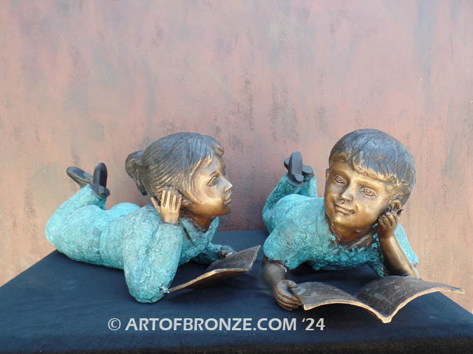 Lil Learners boy and girl pair lying down on their stomachs reading bronze statue