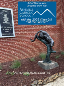 Bronze sculpture of mountain lion crouching on tree branch