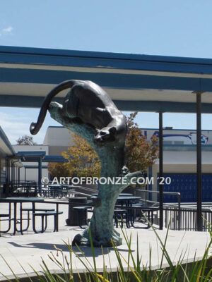 Bronze sculpture of mountain lion crouching on tree branch