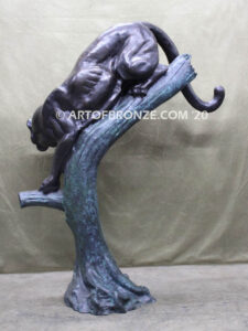 Bronze statue of mountain lion crouching on tree branch