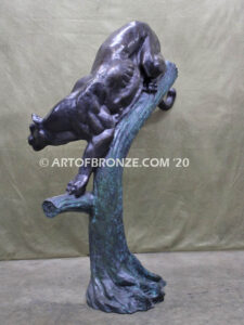 Bronze statue of mountain lion crouching on tree branch