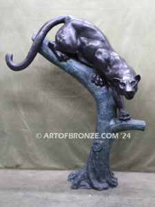 Bronze statue of mountain lion crouching on tree branch