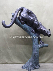 Bronze statue of mountain lion crouching on tree branch