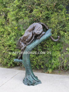 Bronze sculpture of mountain lion crouching on tree branch