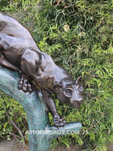 Bronze sculpture of mountain lion crouching on tree branch