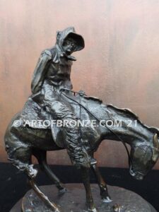The Norther bronze statue after Frederic Remington featuring cowboy caught in forceful winds atop his horse