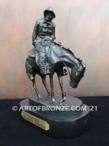 The Norther bronze statue after Frederic Remington featuring cowboy caught in forceful winds atop his horse