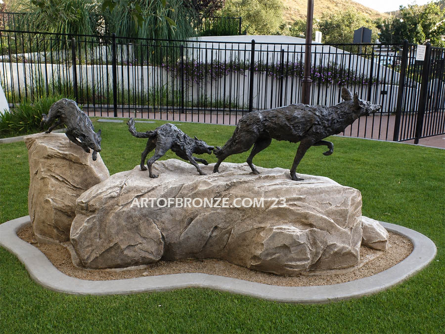 Playful Chase life-size playing coyote family bronze sculpture