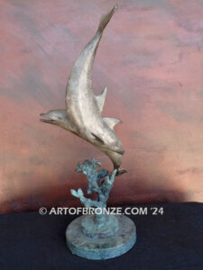 Playmates dolphins playfully swimming together bronze statue