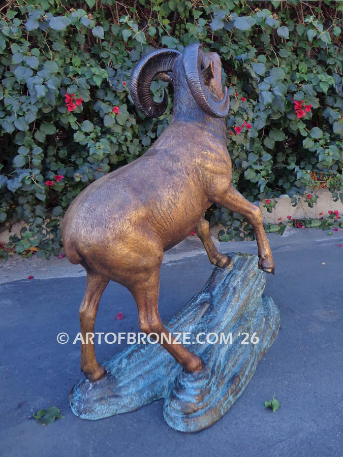 Protected Territory outdoor bronze sculpture of two fighting big horn sheep fighting on bronze rock ledge