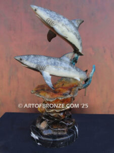 Two swimming great white sharks along a coral reef bronze statue