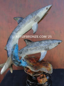Two swimming great white sharks along a coral reef bronze statue