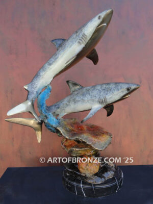 Two swimming great white sharks along a coral reef bronze statue
