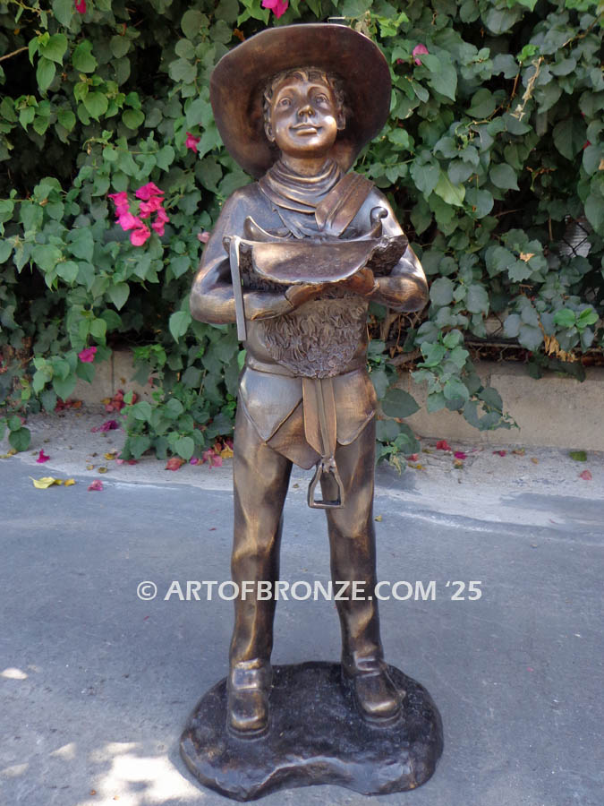 Saddle Up bronze statue of western cowboy kid holding saddle