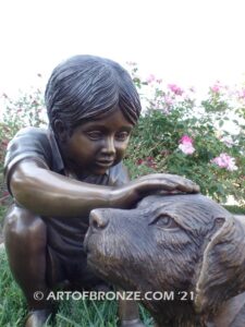 Scrappy bronze garden sculpture of boy playing with his dog