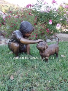 Scrappy bronze garden sculpture of boy playing with his dog