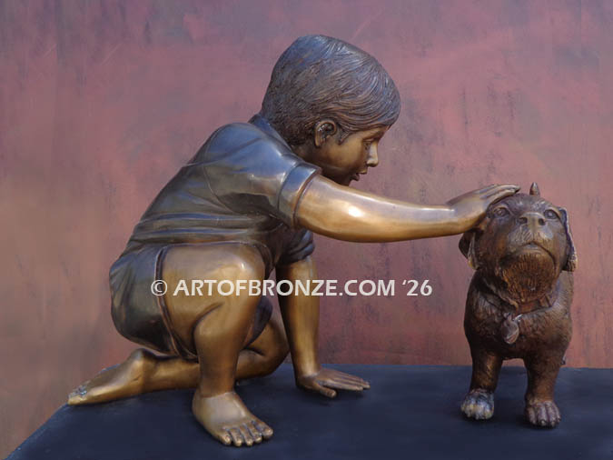Scrappy bronze garden sculpture of boy playing with his dog