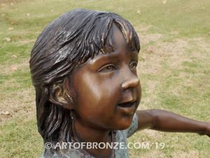 Sing Along wonderful outdoor bronze sculpture featuring three young kids holding hands and dancing