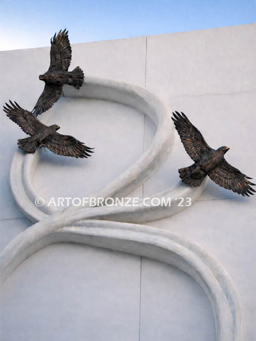 Spirit Above bronze statue of three hawks attached to building wall