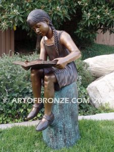 Study Time bronze sculpture of young reader girl sitting on bronze stump